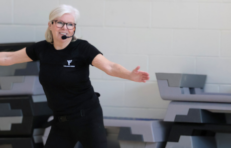 A fitness instructor teaching a class in an indoor gym