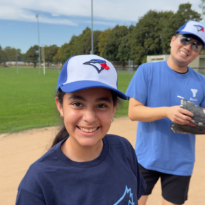 Girl with Jays hat on a baseball field